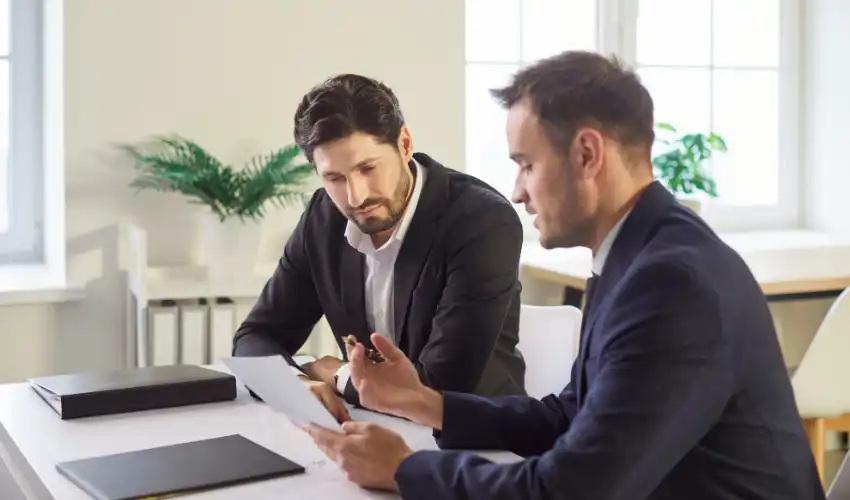 Types of commercial leases UK choosing the right lease — business owner and solicitor reviewing commercial property lease terms at meeting